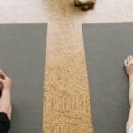 Two senior adults practicing yoga indoors, focusing on relaxation and flexibility.