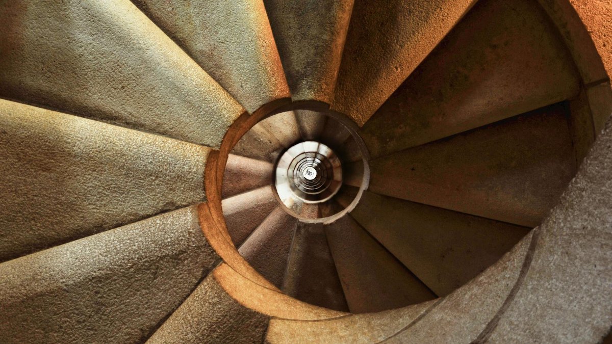 Close-up view of a spiral stone staircase showcasing intricate geometric patterns.