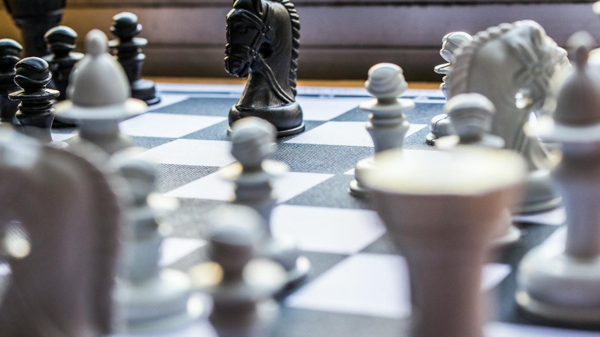 Close-up of a chessboard with pieces in focus, highlighting strategic gameplay.