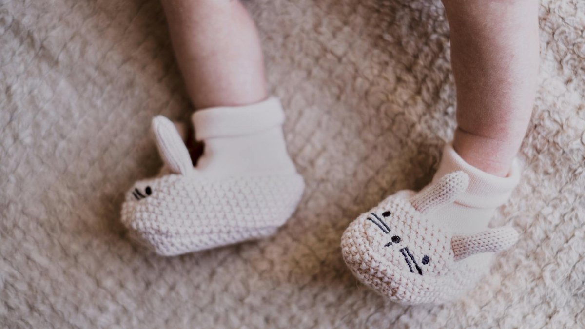 Cute knitted bunny booties on a newborn, perfect for Easter celebrations.