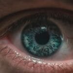 Extreme close-up image capturing the intricate details of a blue human eye with remarkable clarity.