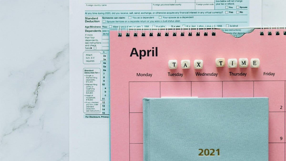 April calendar with tax forms, highlighting tax time reminders for financial tasks.