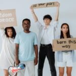 A group of diverse young adults holding protest signs promoting peace and unity.