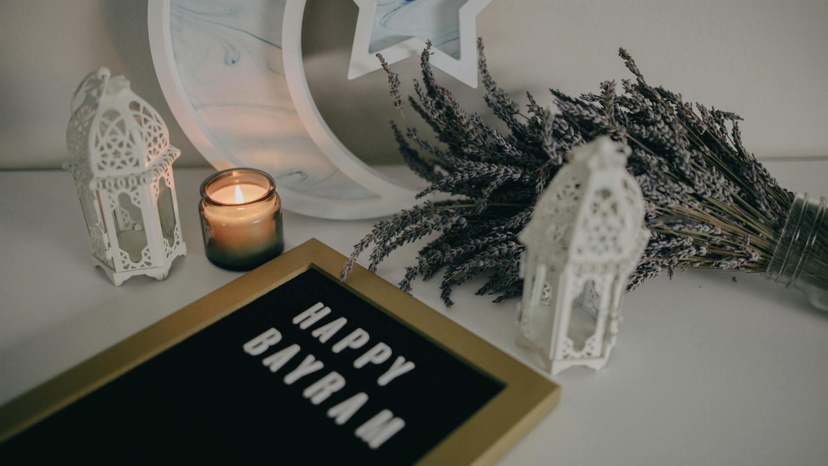 Festive Eid decoration with a Happy Bayram sign, lanterns, and lavender on a table.
