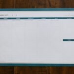 Top view of a blank weekly planner on a wooden surface, perfect for organizing your week.