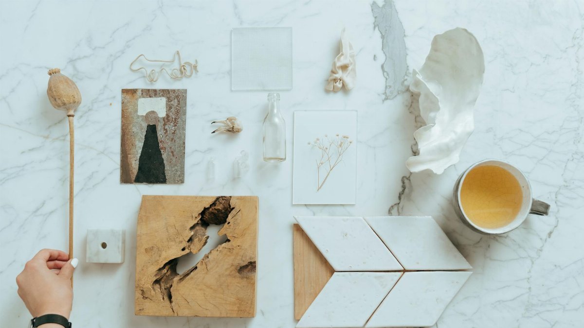Minimalistic flat lay featuring diverse items on a marble background, showcasing natural textures.