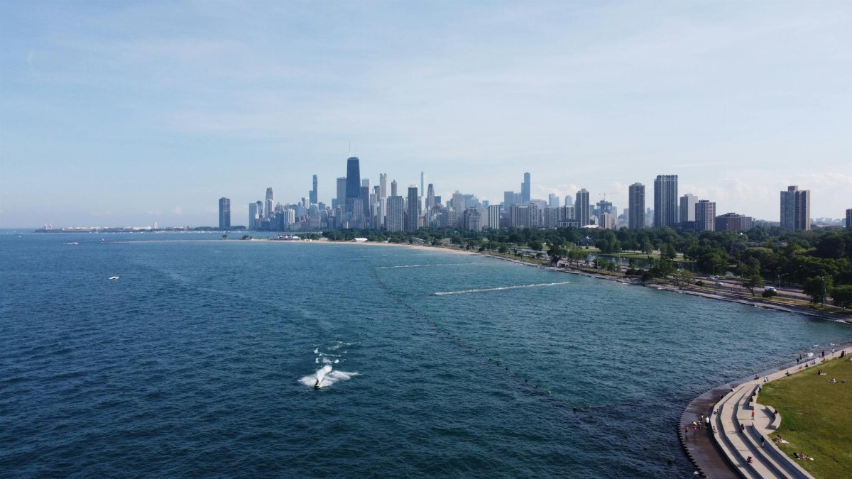 Breathtaking aerial view of Chicago skyline overlooking Lake Michigan with clear blue skies.