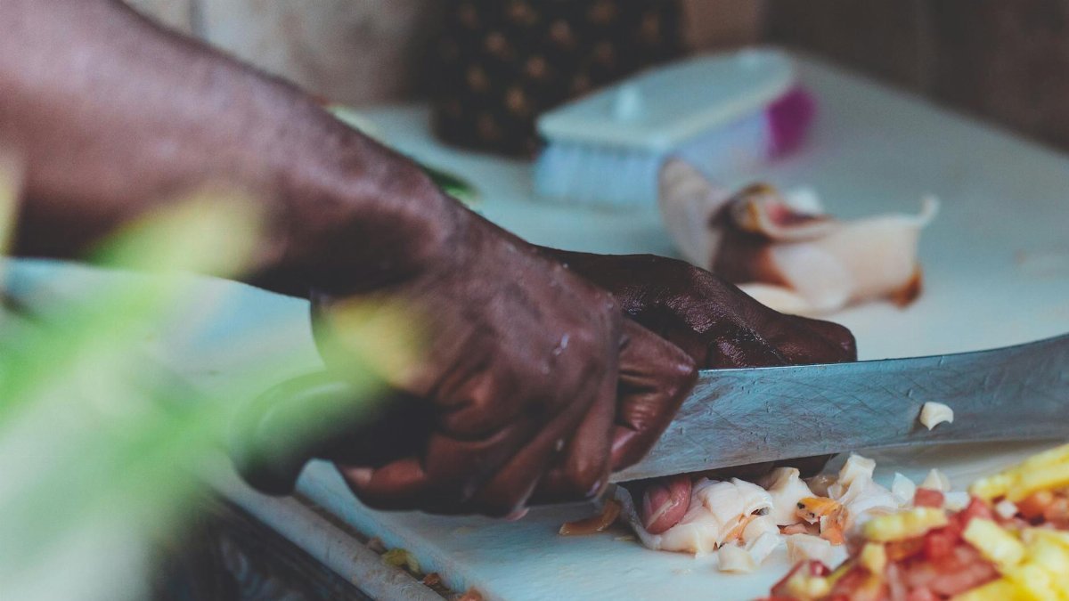 Close-up of a chef chopping fresh ingredients indoors in Nassau, Bahamas.