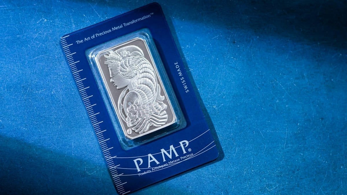 High-quality silver PAMP bar on a striking blue background, emphasizing luxury and security.