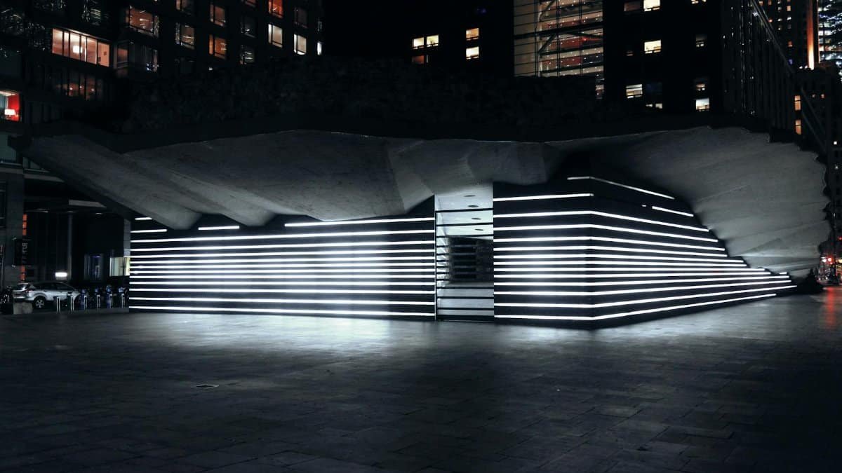 Illuminated Irish Hunger Memorial in New York City at night showcasing modern architecture.