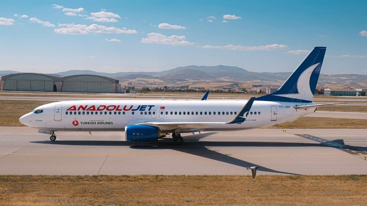 An AnadoluJet Boeing 737 on a sunny day at a Turkish airport runway.