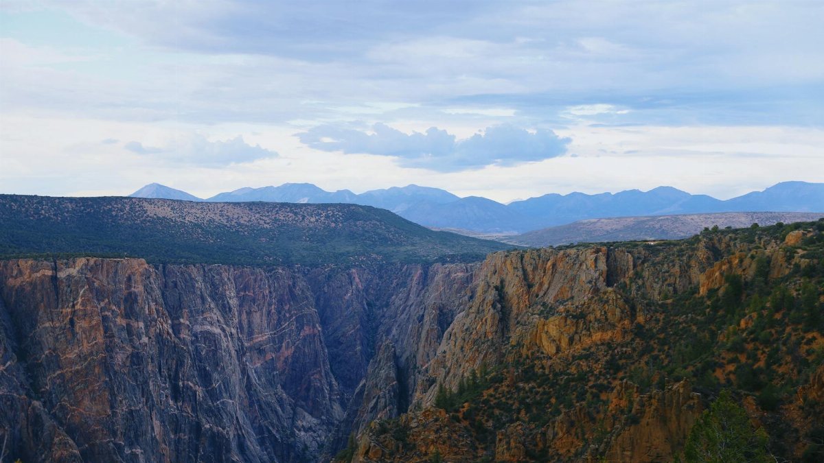 Explore the breathtaking cliffs of Black Canyon, Colorado under clear summer skies.