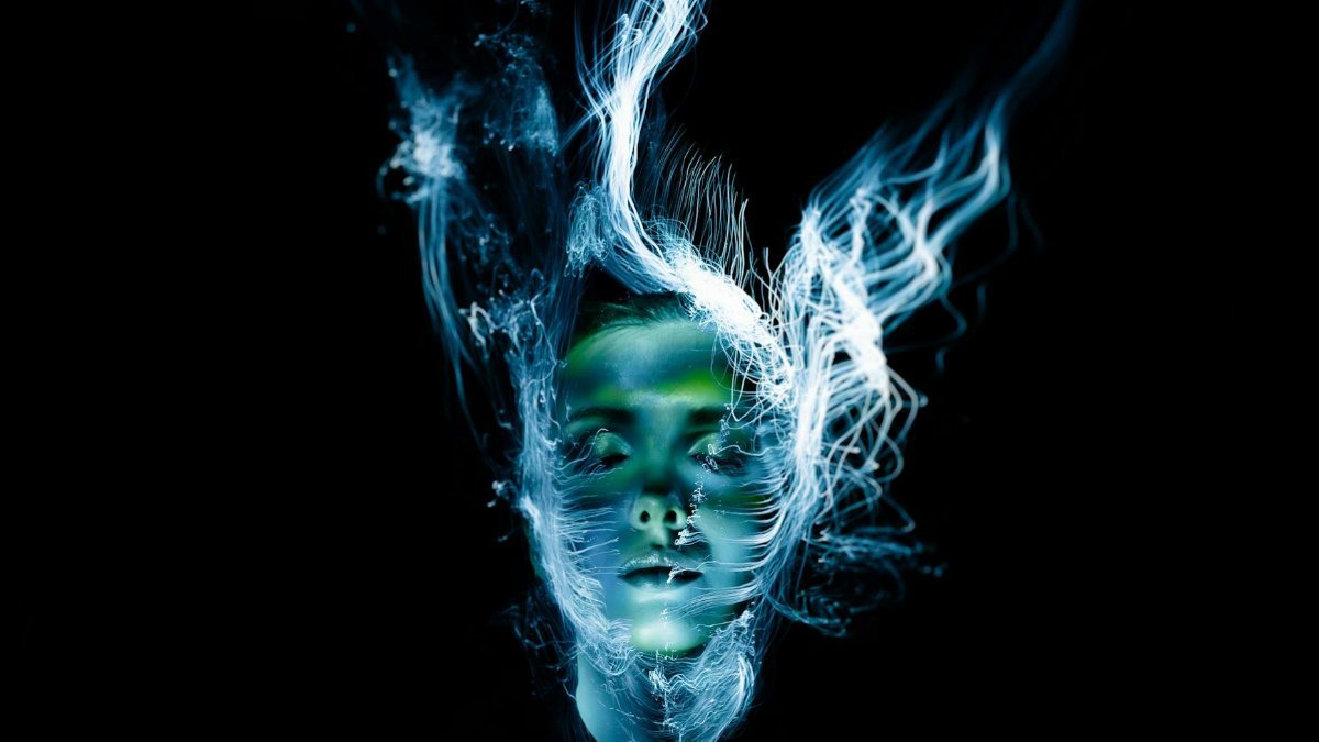 A hauntingly beautiful portrait of a woman with abstract light effects creating a surreal, ethereal appearance.