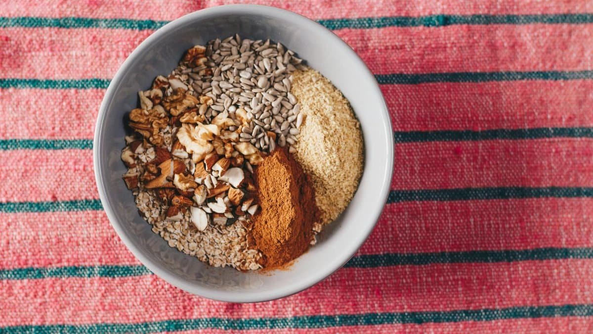 A nutritious blend of oats, nuts, and seeds in a bowl on a vibrant tablecloth.
