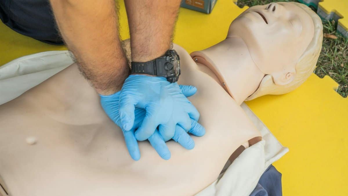 Close-up of hands performing CPR on a manikin for first aid training.