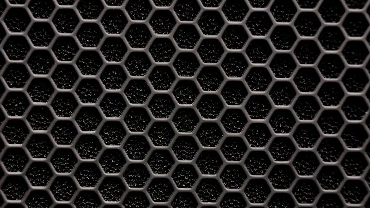Close-up of a metallic hexagonal grid pattern, resembling a honeycomb structure.