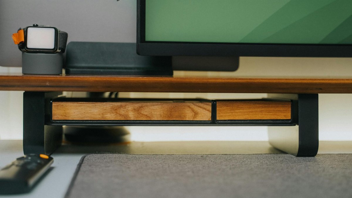 A sleek desk setup with gadgets, wooden accents, and contemporary design elements.