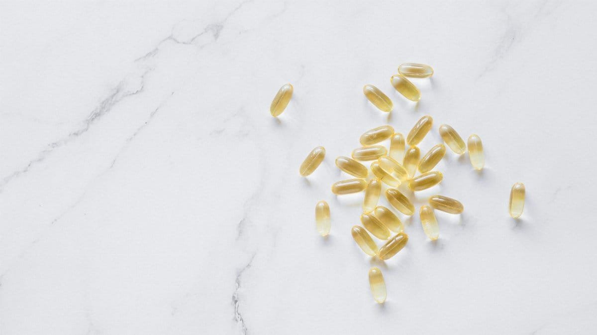 A group of translucent capsules arranged on a marble surface, offering a minimalist aesthetic.
