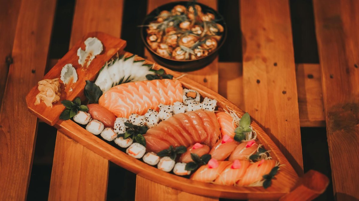 Delicious assortment of sushi including salmon and rolls on a wooden board.