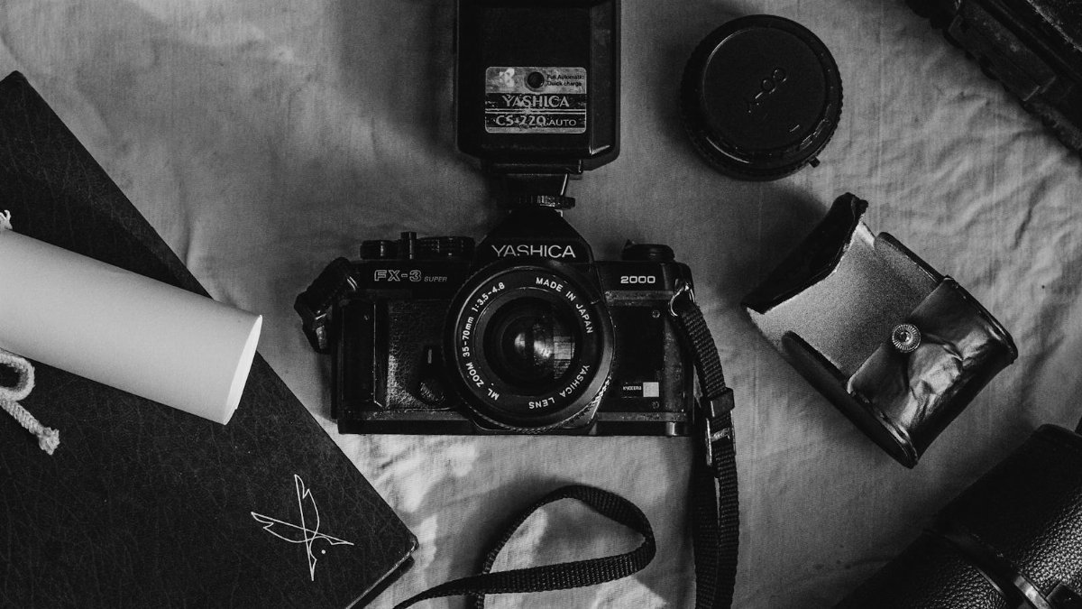 Black and white flat lay of vintage camera equipment, evoking nostalgia.