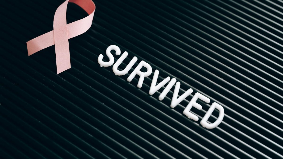 Pink ribbon and 'survived' text symbolize breast cancer awareness and survivorship.