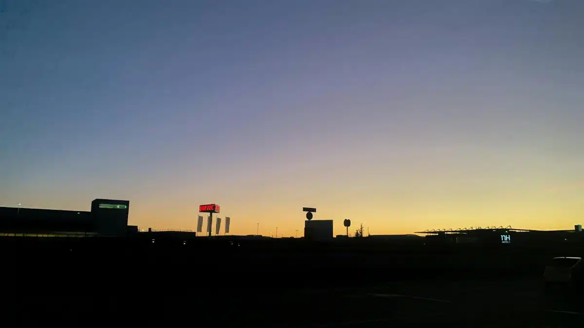 A silhouetted cityscape against a vibrant sunset sky, capturing the calm of twilight.