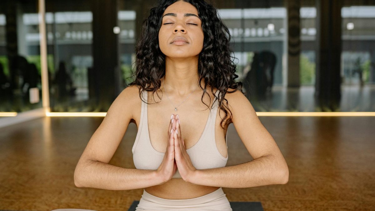 Peaceful woman meditating in a yoga studio, embracing calmness and relaxation.