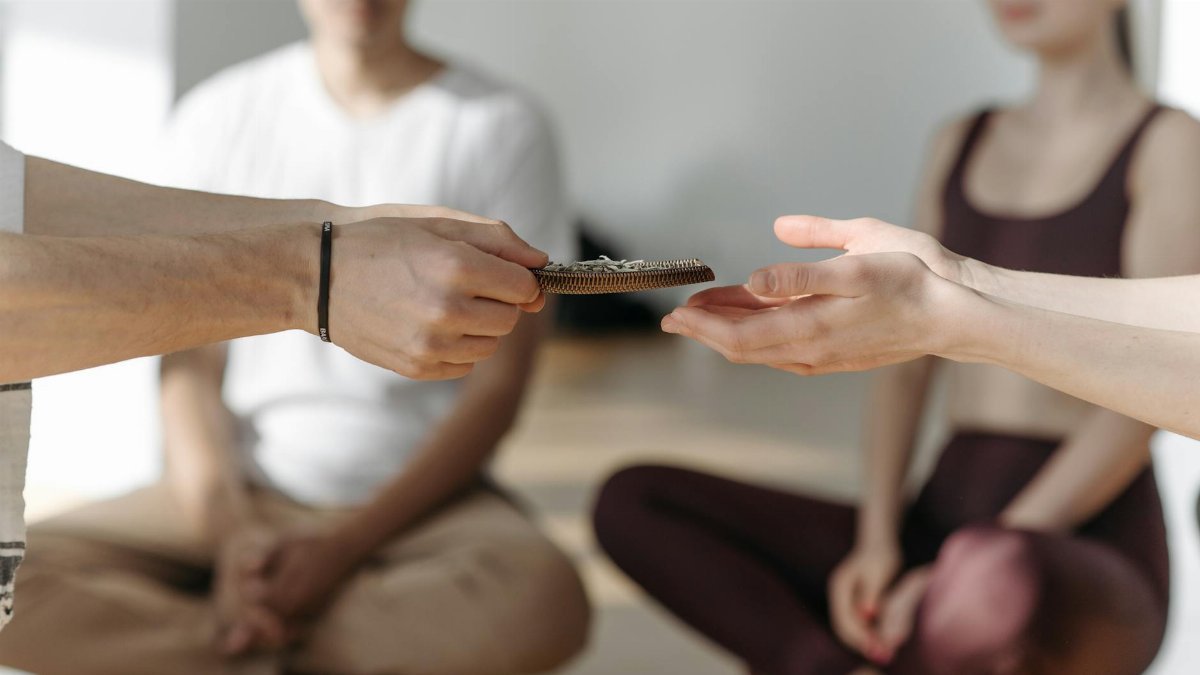 A serene group engaging in meditation with hands passing beads, promoting tranquility and mindfulness.