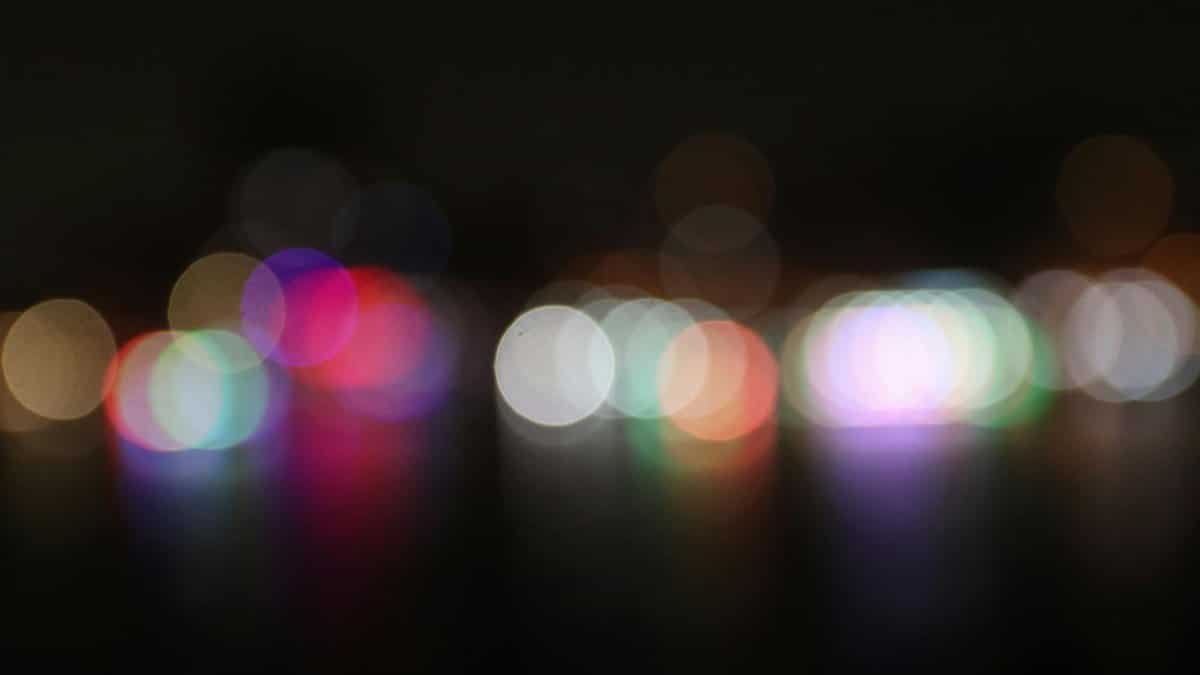Vibrant and colorful bokeh lights defocused against a dark night background, creating an abstract visual.