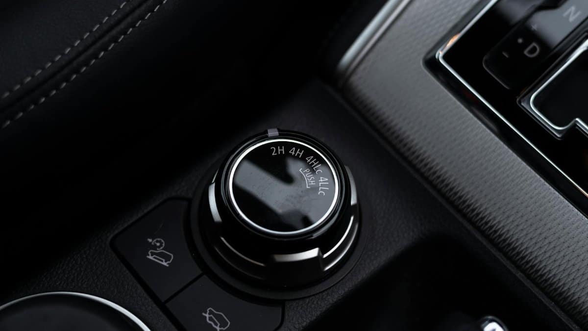 Detailed close-up of a car's gear shift and control knobs, showcasing modern vehicle technology.