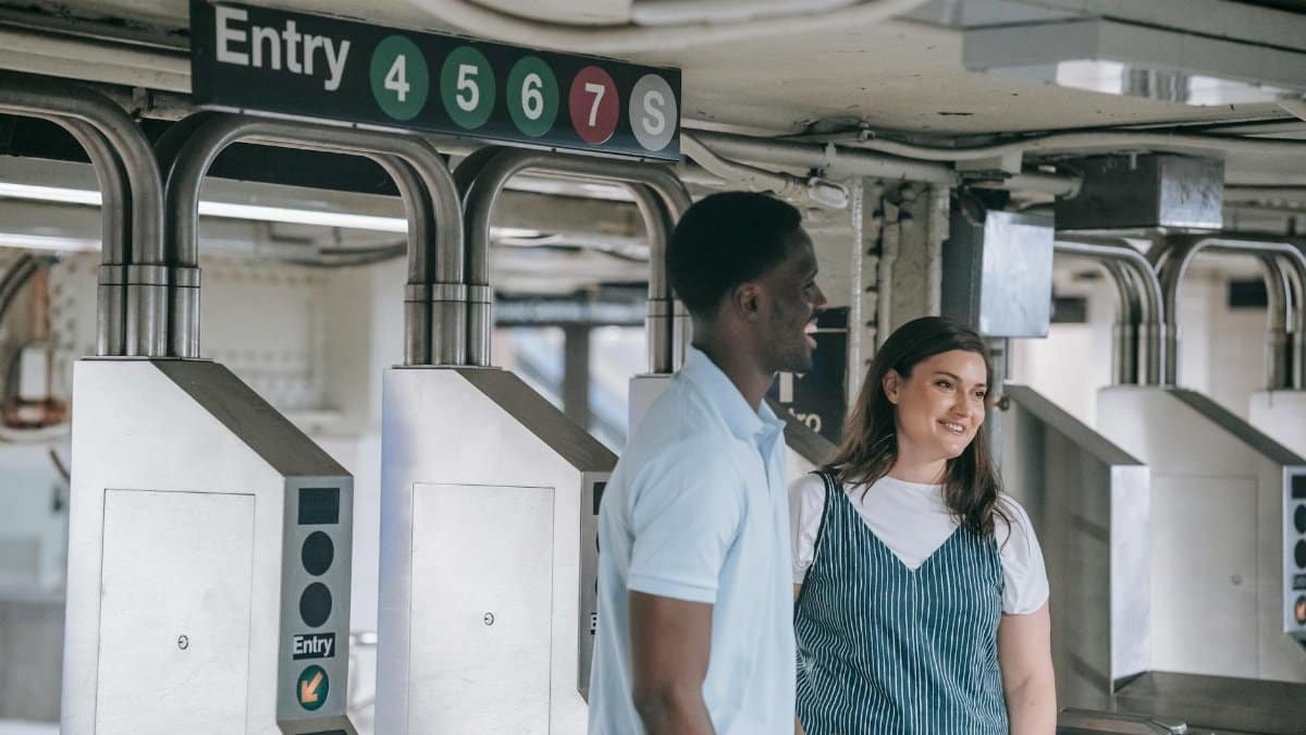 A happy couple entering a subway station, smiling and enjoying their commute.