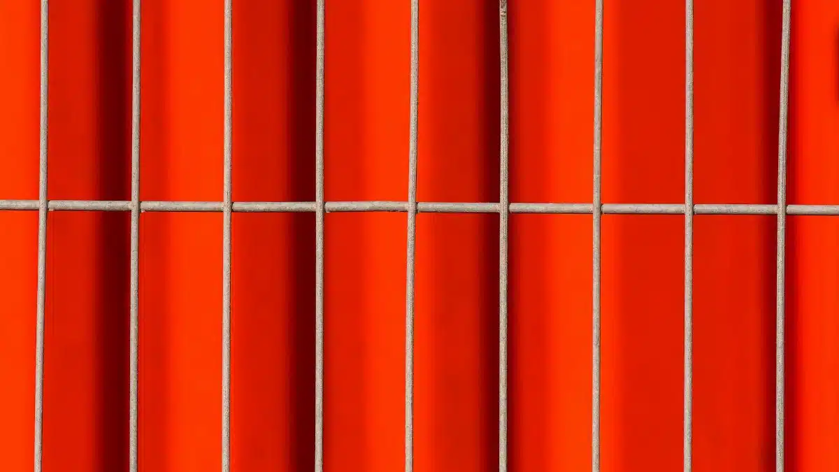 Close-up of an abstract pattern with vibrant red tiles and metal grids, creating a striking visual impact.