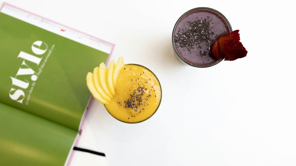 Top view of vibrant mango and berry smoothies garnished with chia seeds, perfect for a healthy treat.
