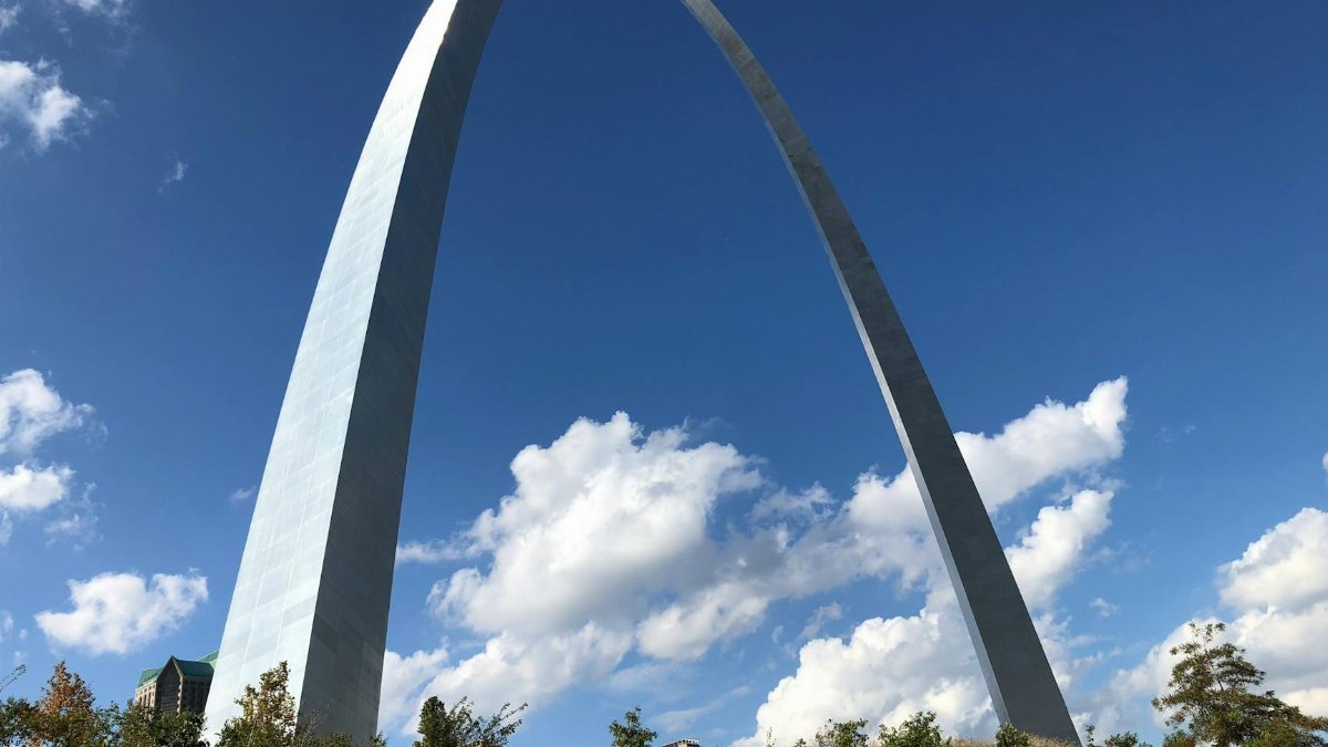 Stunning view of the Gateway Arch in St. Louis, Missouri, against a bright blue sky with clouds.