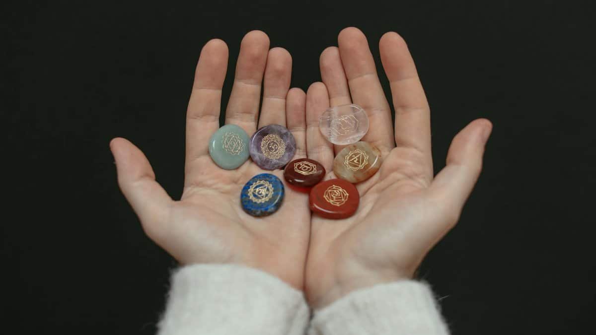 A close-up image of chakra stones held in open hands, showcasing spiritual balance.