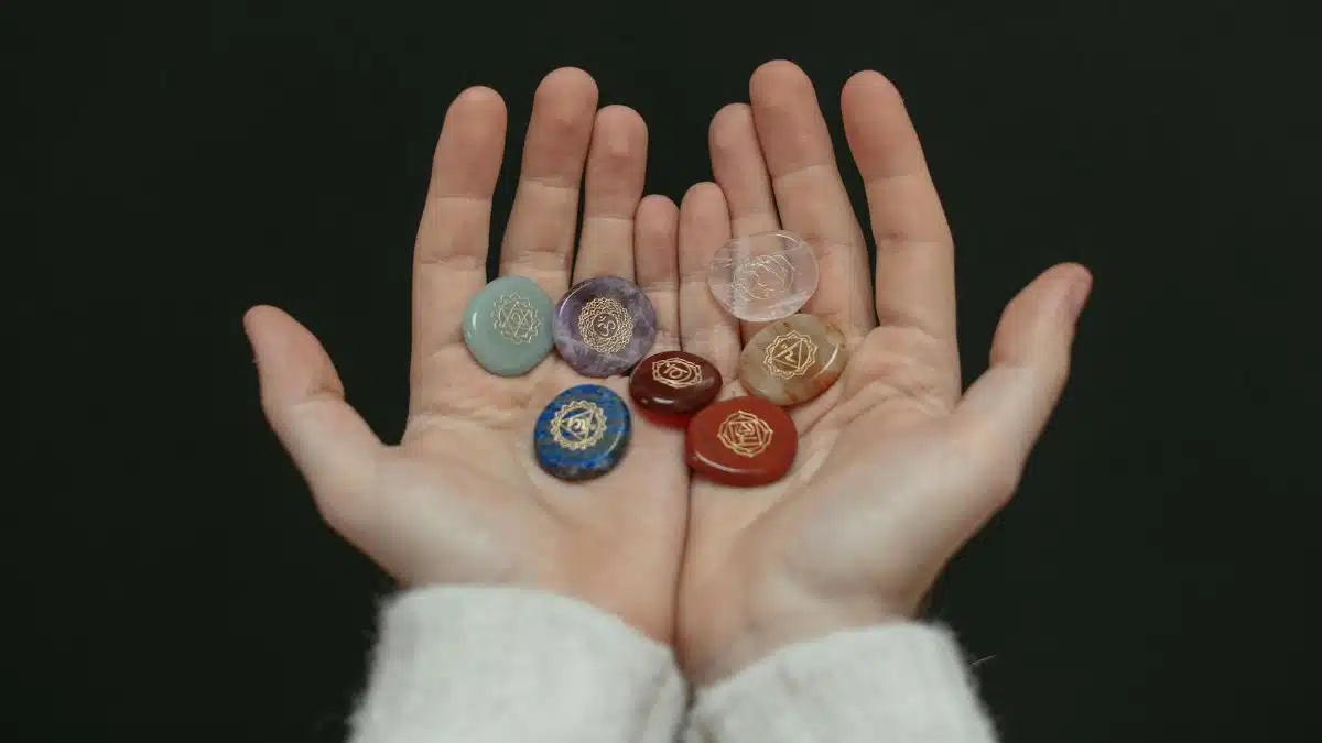 A close-up image of chakra stones held in open hands, showcasing spiritual balance.