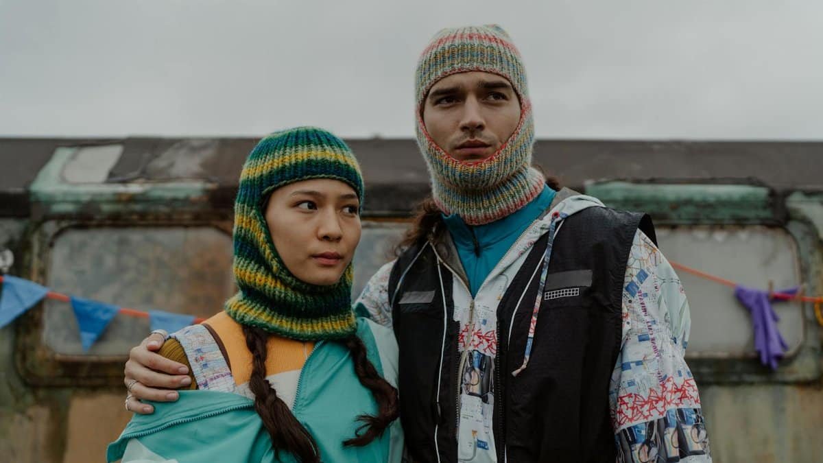 A couple in vibrant knitwear posing confidently outdoors, showcasing unique fashion style.