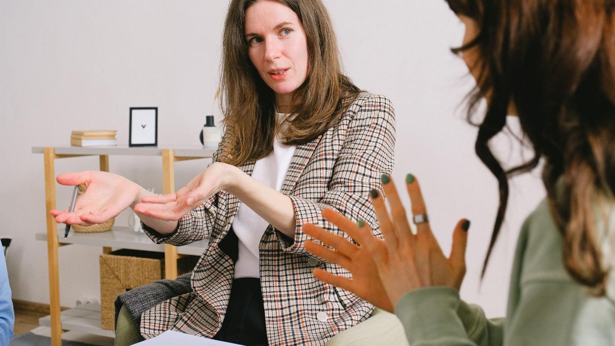 A female professional actively engages in a discussion during an indoor meeting.