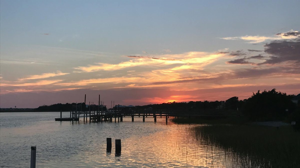 A beautiful sunset at a dock in Myrtle Beach, capturing the reflection on calm waters.
