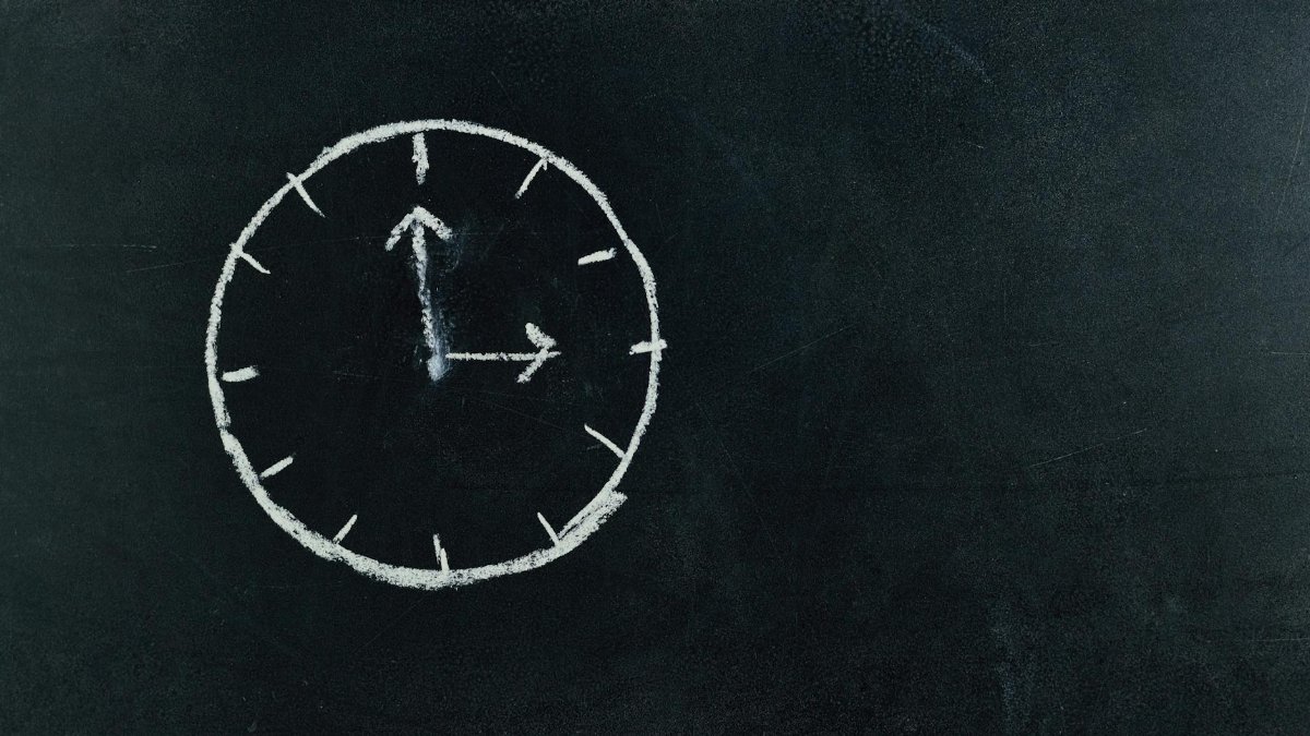 Chalk-drawn clock on a blackboard, symbolizing time and education concepts.