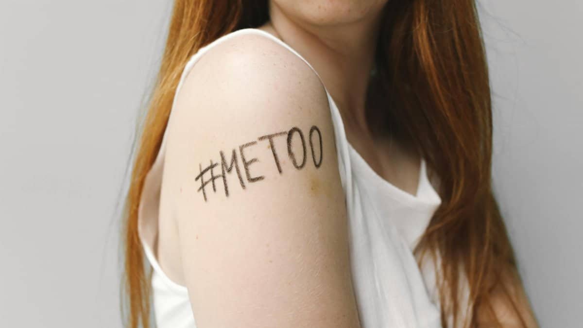 Close-up of a woman with #MeToo written on her arm, symbolizing empowerment and solidarity.