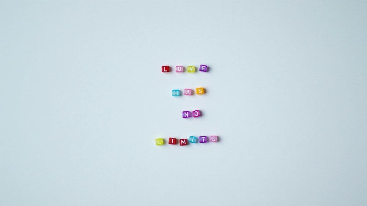 Vibrant bead letters spelling 'Love Has No Limits' on a gray background promoting inclusivity.