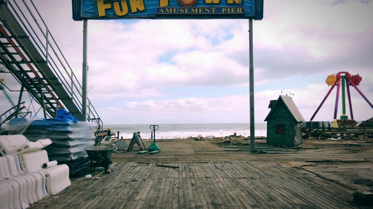 Vintage amusement park pier with empty rides and weathered boardwalk in New Jersey.