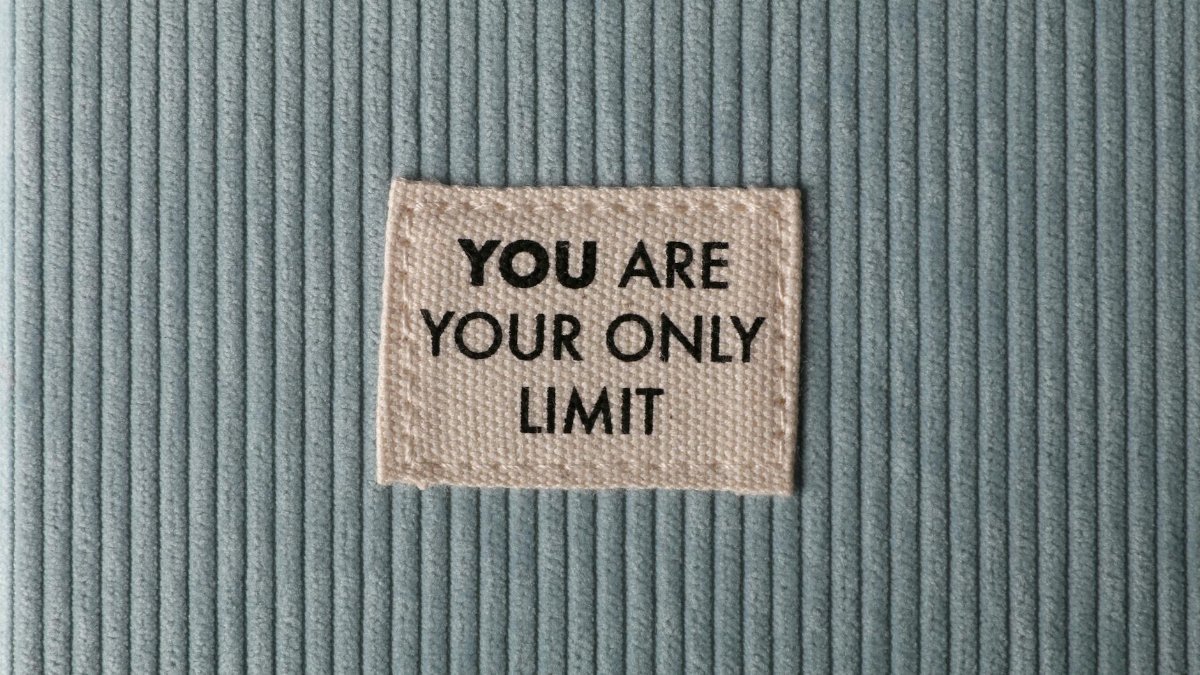 Fabric patch on blue velvet with motivational text 'You Are Your Only Limit' in close-up view.