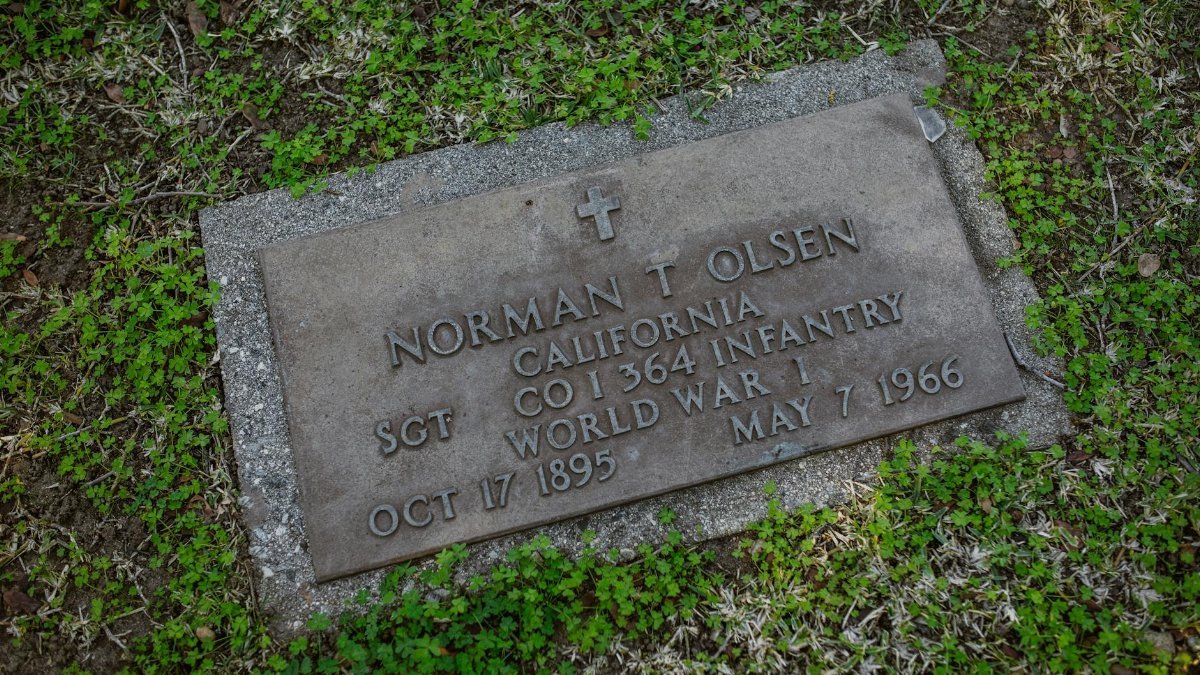 Gravestone of Sgt. Norman T. Olsen, World War I veteran, in a green cemetery.