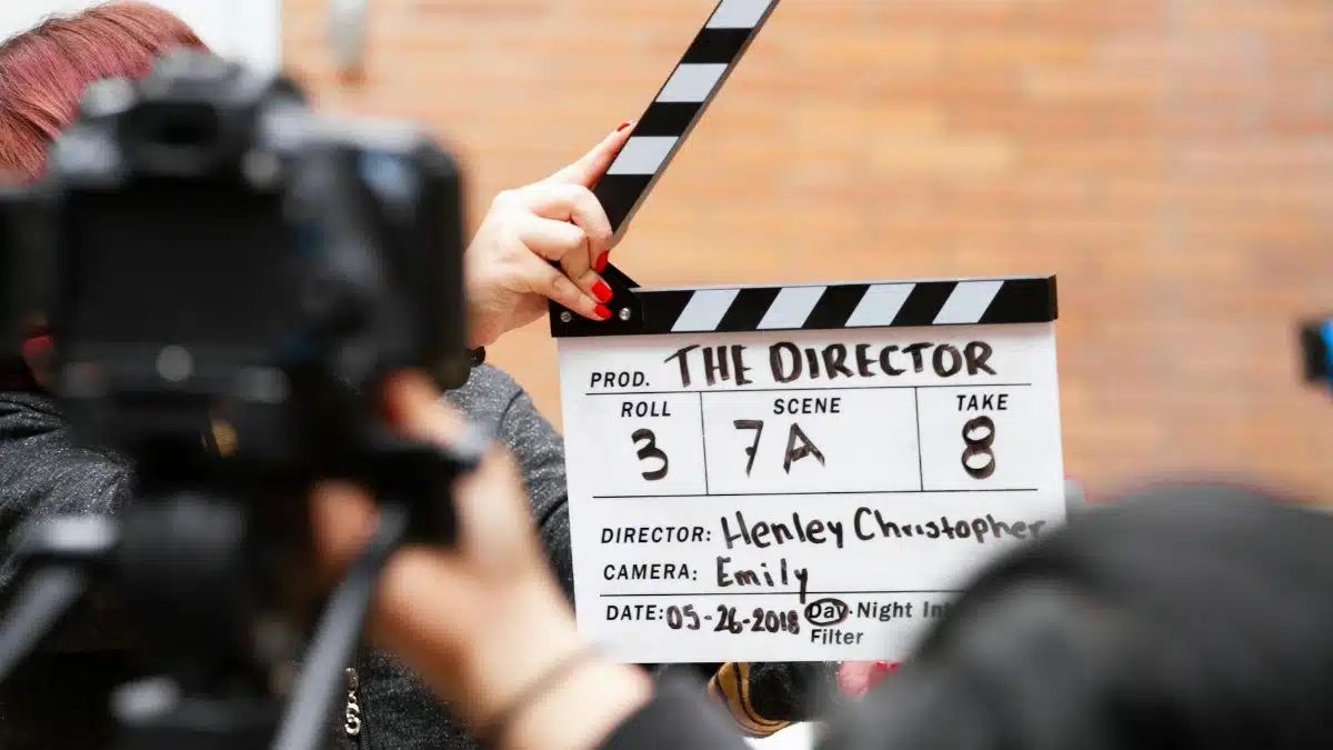 Close-up of film clapperboard in action with camera filming a take on set.