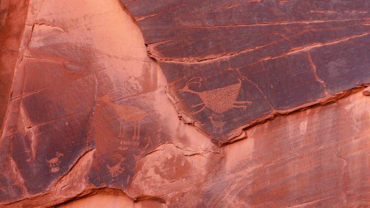Close-up of ancient petroglyphs etched into sandstone walls in Monument Valley.