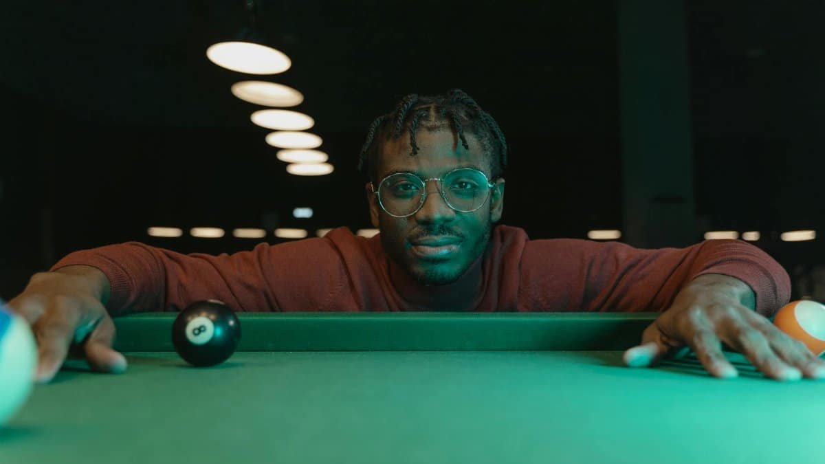 Man focusing intently on a billiard shot, showcasing precision and skill.