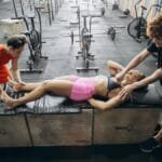 Athletes engage in recovery therapy with cupping and massage in a gym.