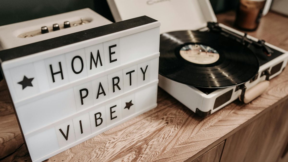 A cozy and retro vibe with a vinyl turntable and 'Home Party Vibe' sign.